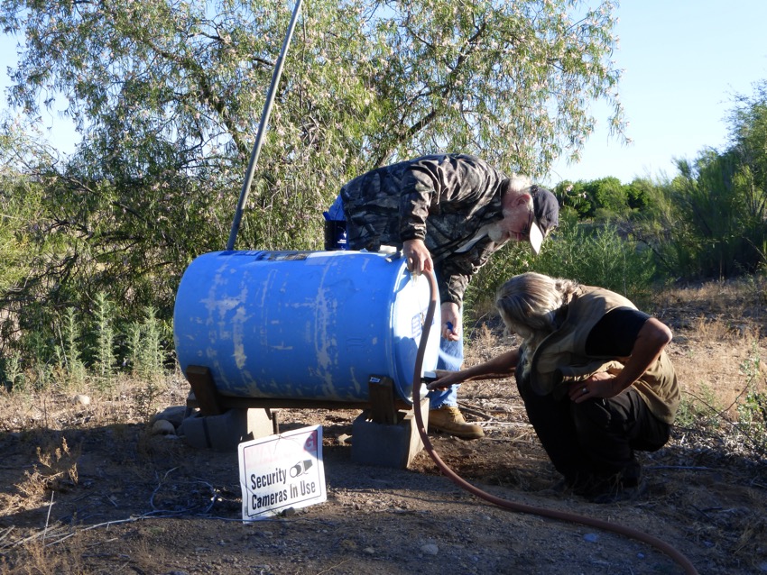Filling a water tank with water. Notice the surveillance sign